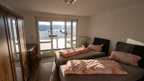 ein Wohnzimmer mit 2 Betten und einem Balkon in der Unterkunft Ferienwohnung Hochtal in Bernau im Schwarzwald