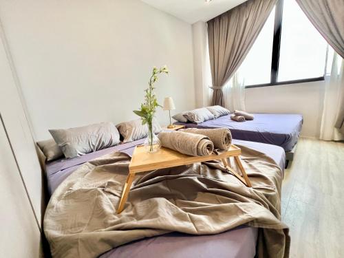 twee bedden in een kamer met een tafel erop bij LA 1-10 Pax Cozy Home Tropicana 3Rooms 4QBeds Wifi&TV in Petaling Jaya