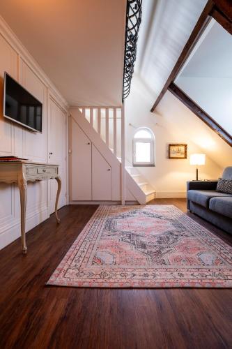 an attic living room with a couch and a tv at Hotel Restaurant Café Parkzicht in Roermond