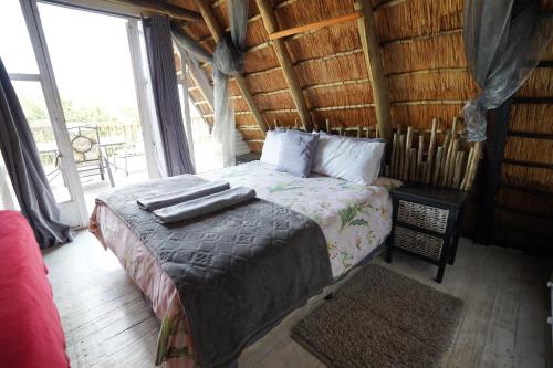 1 dormitorio con 1 cama en una cabaña de madera en Rustic River & Bush Escape, en Buffelspoort
