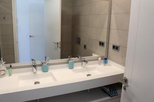 La salle de bains est pourvue de 2 lavabos et d'un grand miroir. dans l'établissement Sunset Drive, Cerca de la playa Poniente, à Benidorm