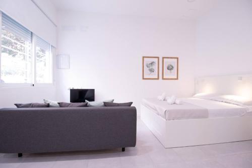 a white room with two beds and a couch at Viveros by Concept Flats in Valencia