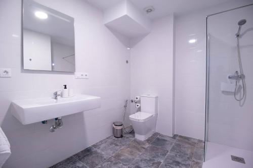 a white bathroom with a sink and a toilet at Viveros by Concept Flats in Valencia