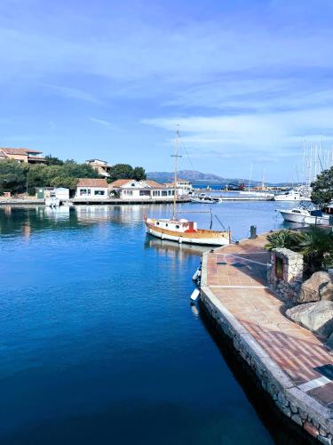 a boat is docked in the water near a dock at Porto Rotondo centro - splendido appartamento con terrazza in Porto Rotondo