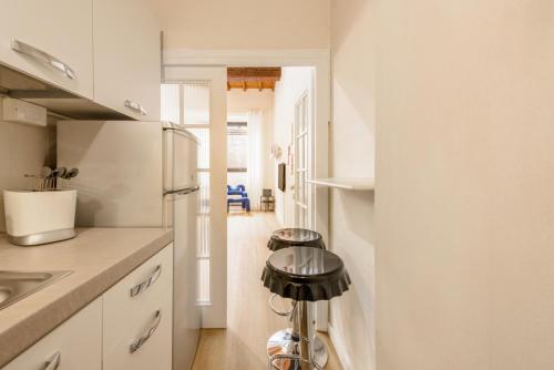 a kitchen with white cabinets and a refrigerator at Orsanmichele View by Mmega in Florence
