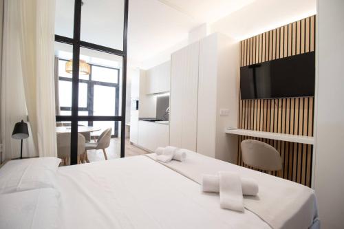 a white bedroom with a large bed with two towels at MARITIM 2 by Concept in Valencia