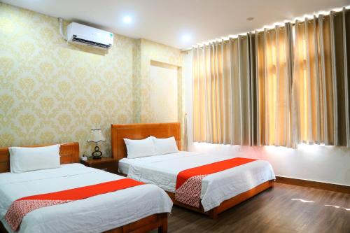 a hotel room with two beds and a window at Luxury Airport Hotel & Travel in Noi Bai