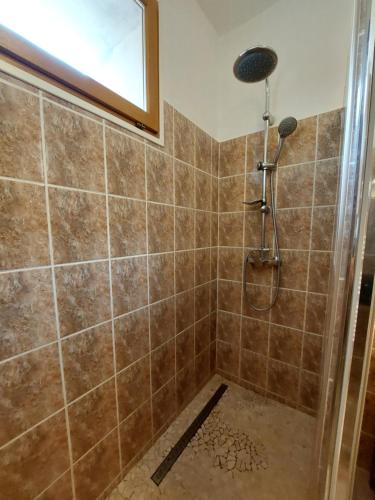 La salle de bains est pourvue d'une douche et d'un mur carrelé. dans l'établissement Gite Europa, à Le Mas