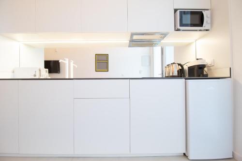 a kitchen with white cabinets and a microwave at Marino by Clink in Valencia
