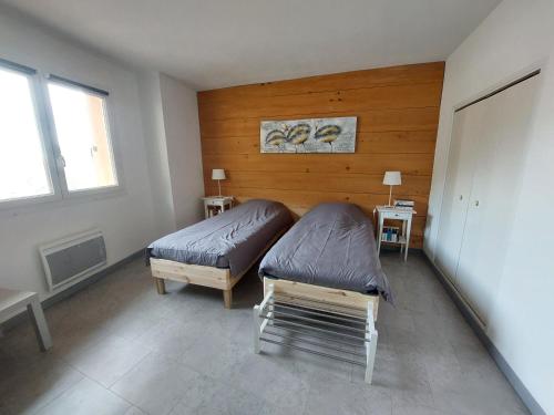 Le Mas的住宿－Gîte Bistrot，一间卧室设有两张床和两个窗户。
