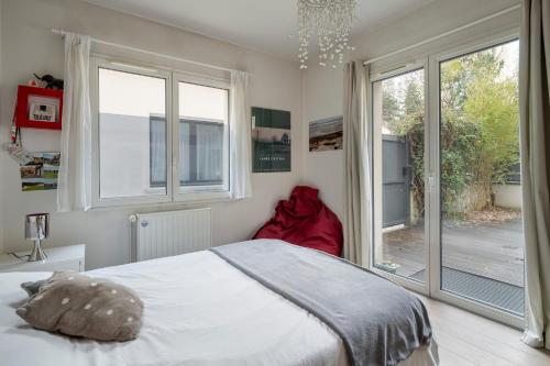 een slaapkamer met een bed en een groot raam bij Atypical Luxury House near Paris in Boulogne-Billancourt