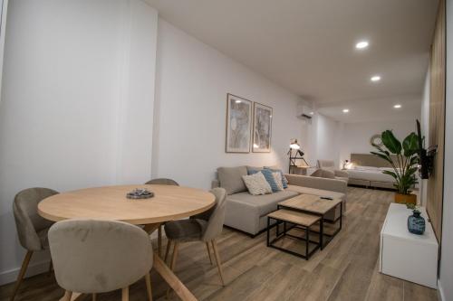 uma sala de estar com uma mesa e um sofá em Cid Flats by Concept em Valência