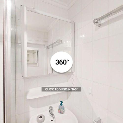 a white bathroom with a sink and a mirror at Komfort Appartement Sylt - direkt am Strand - in Westerland (Sylt)