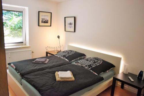 a bedroom with a bed with black sheets and pillows at Möwennest am Twedter Holz in Flensburg