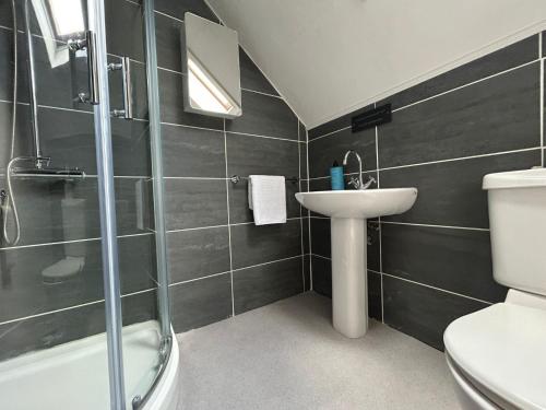 a bathroom with a sink and a shower and a toilet at Dog friendly 6- Bedroom House in Isle of Lewis - great for families and large groups in Garrabost