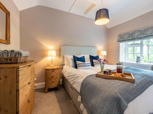 a bedroom with a bed with a tray of food on it at 3 Bed in Ross-on-Wye 75491 in Llangarren