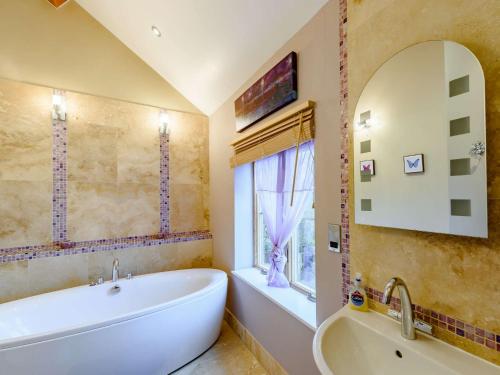 baño con bañera, lavabo y ventana en 2 Bed in Conwy 74147, en Eglwys-Fâch