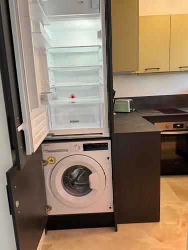 a refrigerator with a washing machine in a kitchen at Studio climatisé 600m de la plage in Cagnes-sur-Mer