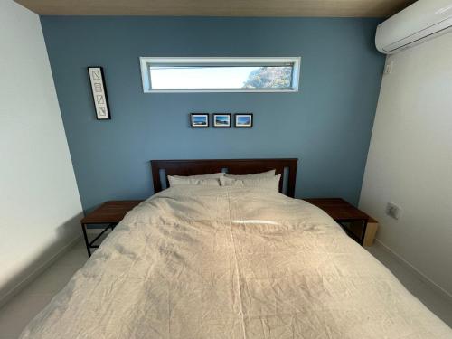 a bedroom with a large bed with a window at さんぽ 1日1組限定のプライベートヴィラ in Hayama