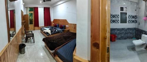 ein Zimmer mit einem Bett und einer Couch darin in der Unterkunft NEW SAMY CAFE AND HOMESTAY in Kasol