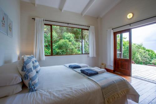 a bedroom with a bed and a large window at Mar Azul 1B in Ponta Malangane