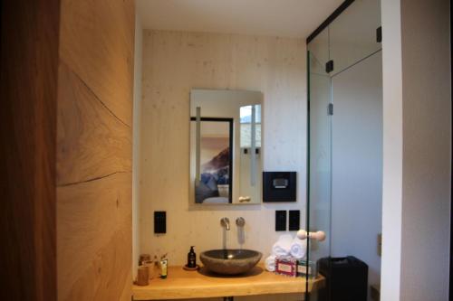 een badkamer met een wastafel en een spiegel bij Alpenlodges in Schönau am Königssee