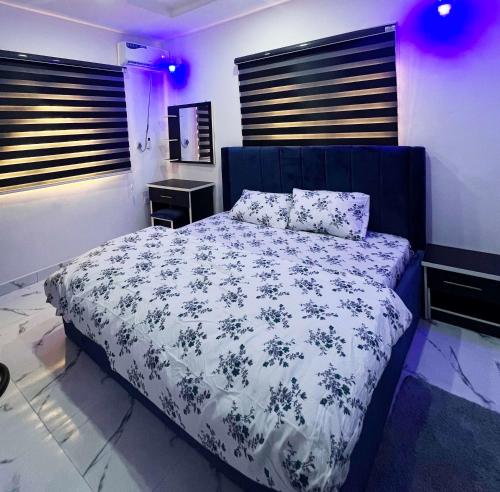 sypialnia z łóżkiem z niebiesko-białą kołdrą w obiekcie Signature Residence w mieście Calabar