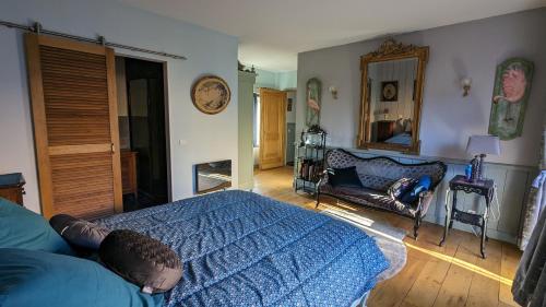 ポンにあるChambre d'Hôtes La Grenade Bleueのベッドルーム(ベッド1台、ソファ、鏡付)