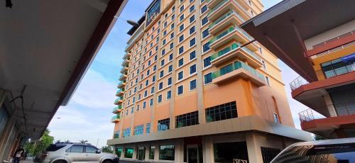 a tall building with a car parked in front of it at Hotel Kapalai Semporna in Semporna