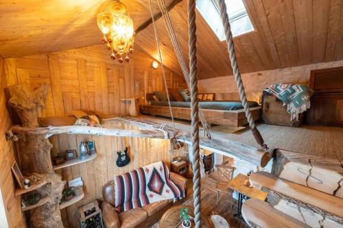 Cette chambre se trouve dans une cabane en rondins dotée d'un lit et d'un canapé. dans l'établissement la Kahutte, à La Rochelle