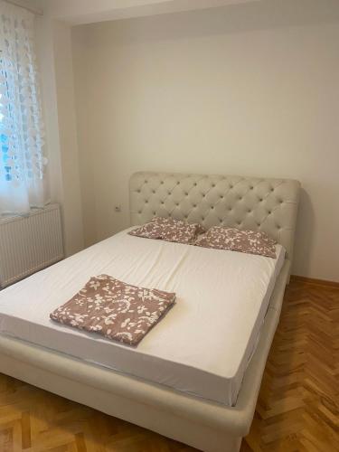 een bed in een kamer met een wit bedframe bij Vlada apartment 2 in Vranje