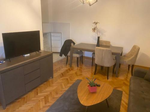 een woonkamer met een eettafel en een televisie bij Vlada apartment 2 in Vranje