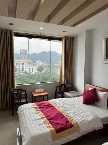 a bedroom with a bed and a large window at Thiên Thiên Thanh in Lao Cai