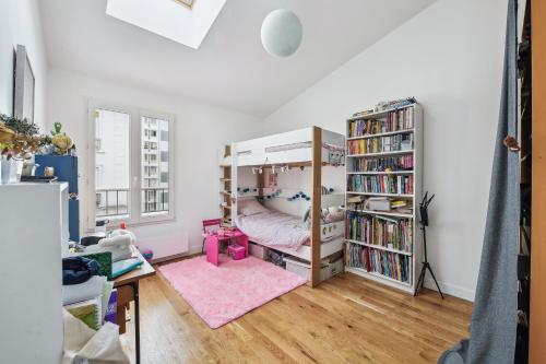 a bedroom with a bunk bed and a book shelf at Duplex familial à necker by Weekome in Paris