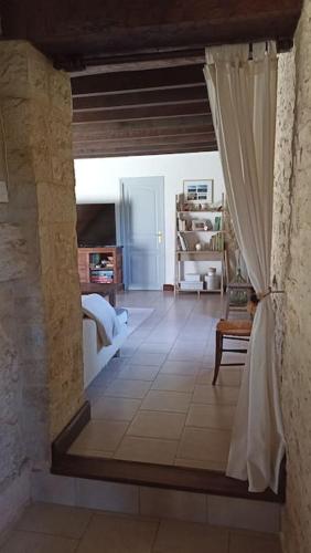 une vue d'une chambre avec un lit et un rideau dans l'établissement Les Tavernes*Authentique*Calme*Piscine, à Daglan