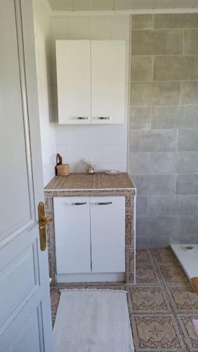 une salle de bain avec un lavabo et un meuble blanc dans l'établissement Les Tavernes*Authentique*Calme*Piscine, à Daglan