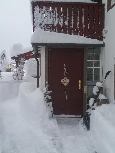 a house covered in snow next to a building at Haus Biggi - Ferienwohnung Säntis in Weiler-Simmerberg