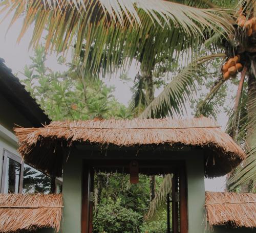 a straw roof over the door of a house at Ardan Maison Ubud in Ubud