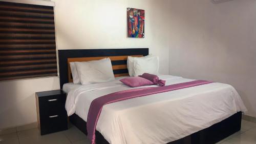 a bedroom with a large bed with white sheets at WORK AND PLAY PLACE(WPP) in Ikeja