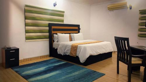 a bedroom with a bed and a desk and a chair at WORK AND PLAY PLACE(WPP) in Ikeja