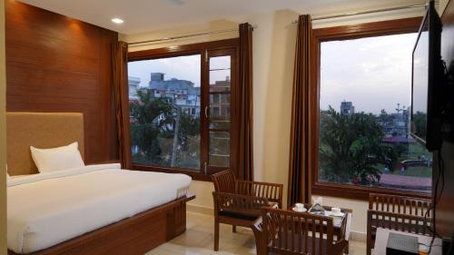 a bedroom with a bed and a large window at Hotel Park Street in Pathānkot