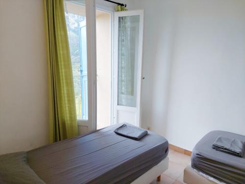 een kleine slaapkamer met een bed en een raam bij Hellebore in Le Mas