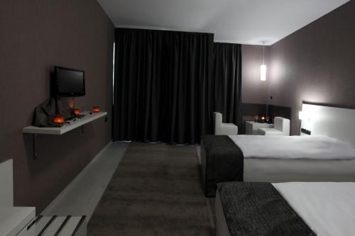 a hotel room with two beds and a television at Hotel Idol in Targovishte