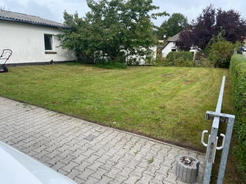 a house with a yard with a brick driveway at KAPITÄNS HUS 1 - Sauna, großer Garten, 400m zum Strand in Graal-Müritz