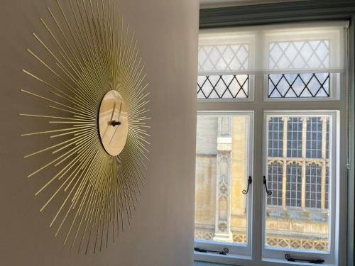 een klok aan een muur naast een raam bij Cathedral View Apartment, Flat 4 in Bury Saint Edmunds