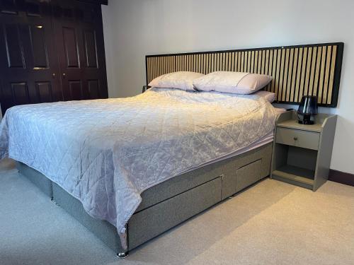 a bedroom with a bed with a wooden headboard at Cathedral View Apartment, Flat 4 in Bury Saint Edmunds
