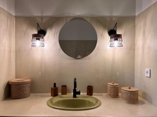 科尔巴拉Casa Rose - Maison vue mer !的浴室设有水槽、两盏灯和镜子