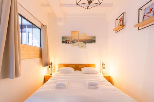 une chambre avec un lit avec des draps blancs et une fenêtre dans l'établissement Le Bonascre - Station de ski à pied, à Ax-les-Thermes
