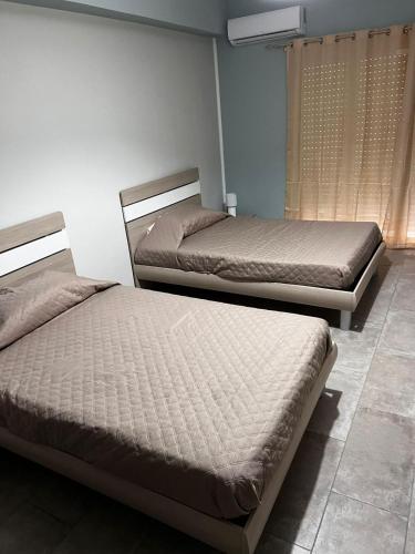 two beds sitting in a room withermottermottermott at Damilhouse 7 in Messina