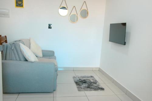 sala de estar con sofá azul y TV en Family Eco Thermas, en Olímpia